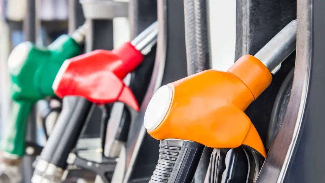 Close-up of orange, red, and green fuel pump nozzles at gas station for car refueling